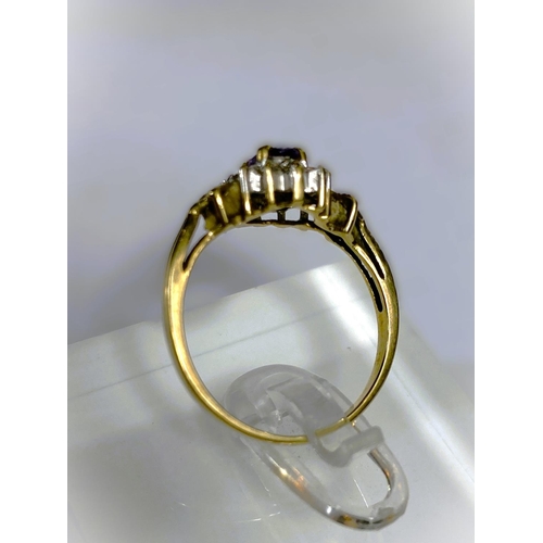 668 - A yellow metal wide ring, stamped 375, with Greek key style decoration, set oval peridot coloured st... 