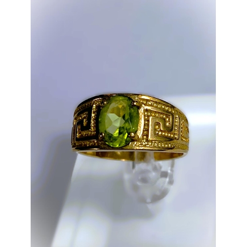 668 - A yellow metal wide ring, stamped 375, with Greek key style decoration, set oval peridot coloured st... 