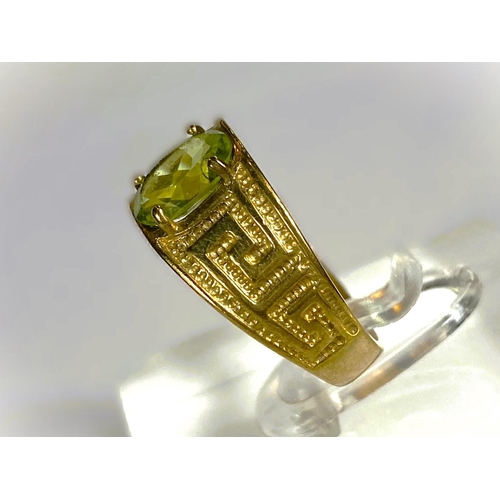 668 - A yellow metal wide ring, stamped 375, with Greek key style decoration, set oval peridot coloured st... 