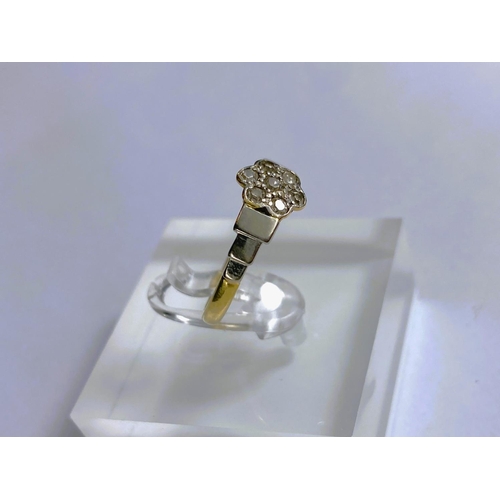 669 - A yellow metal dress ring stamped '18ct plat' set 7 diamonds as a flowerhead, 2.8gm, size K