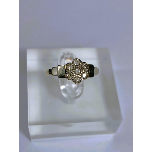 669 - A yellow metal dress ring stamped '18ct plat' set 7 diamonds as a flowerhead, 2.8gm, size K