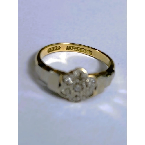 669 - A yellow metal dress ring stamped '18ct plat' set 7 diamonds as a flowerhead, 2.8gm, size K