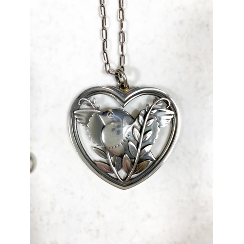 678 - Georg Jensen:  a pierced silver heart shaped pendant, bird with outstretched wings perched in b... 