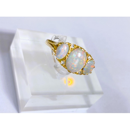 682 - An 18 carat gold dress ring set large central opal flanked by 2 smaller opals and 4 small diamonds