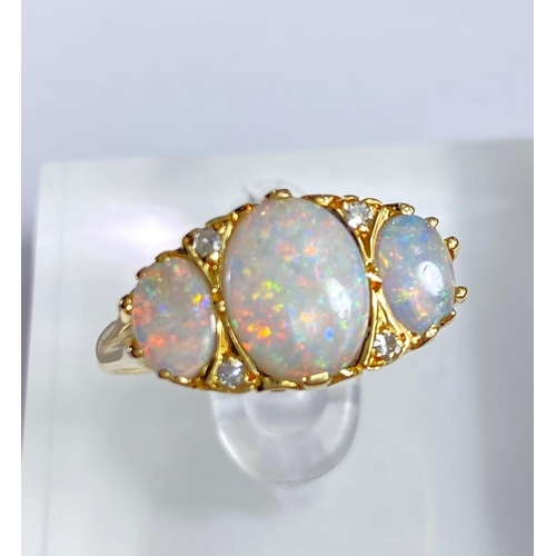 682 - An 18 carat gold dress ring set large central opal flanked by 2 smaller opals and 4 small diamonds