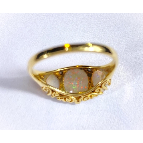 682 - An 18 carat gold dress ring set large central opal flanked by 2 smaller opals and 4 small diamonds