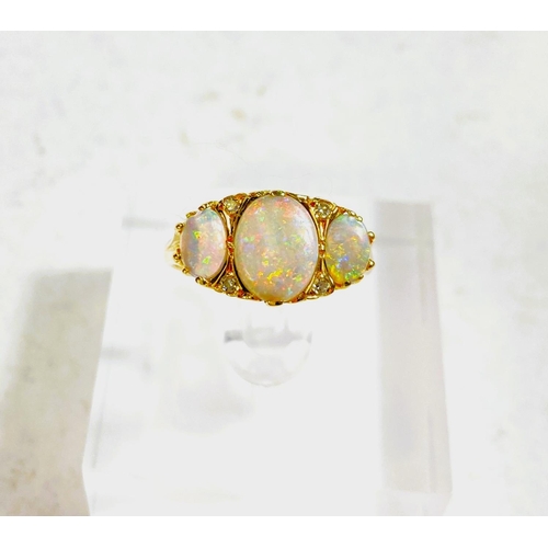 682 - An 18 carat gold dress ring set large central opal flanked by 2 smaller opals and 4 small diamonds