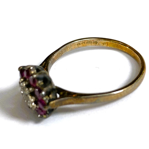 684 - A yellow metal ring stamped 18ct with central illusion set diamond surrounded by rubies, 4.2gm