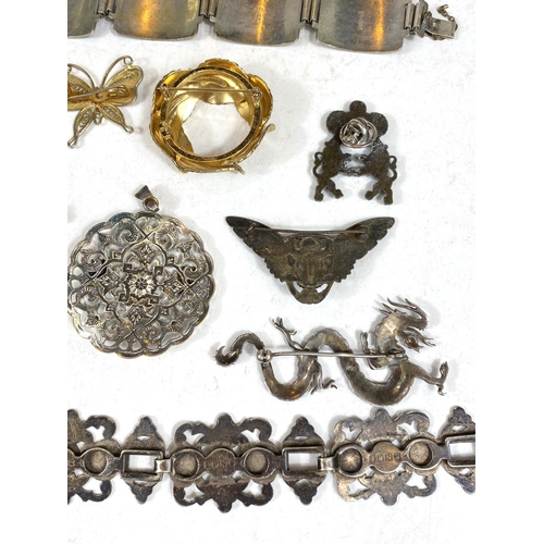 695 - A Chinese white metal dragon brooch stamped 925; a white metal continental bracelet with Viking ship... 