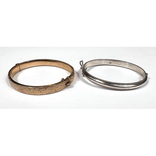 708 - A 9ct gold bangle, 9.4oz and a white metal bangle stamped 925