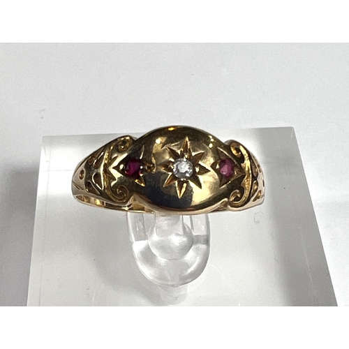 727A - A lady's gold dress ring with central diamond in star cut surround flanked by 2 small rubies, shank ... 