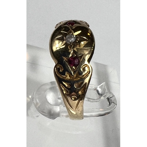 727A - A lady's gold dress ring with central diamond in star cut surround flanked by 2 small rubies, shank ... 