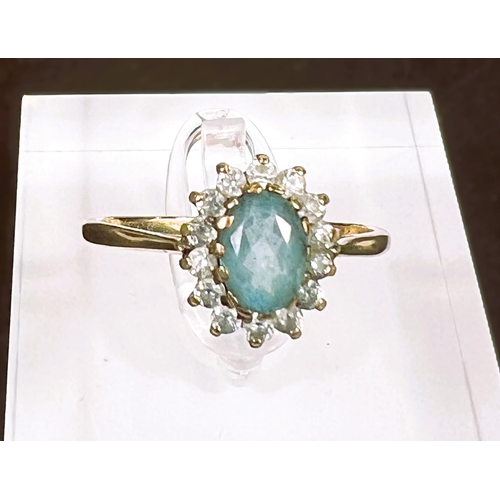 763 - A 9 carat hallmarked gold dress ring set with a central turquoise coloured stone surrounded by clear... 