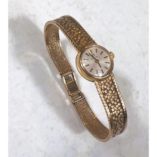 766 - A ladies 9 carat hallmarked gold OMEGA wristwatch with integral hallmarked gold bark effect strap, 1... 