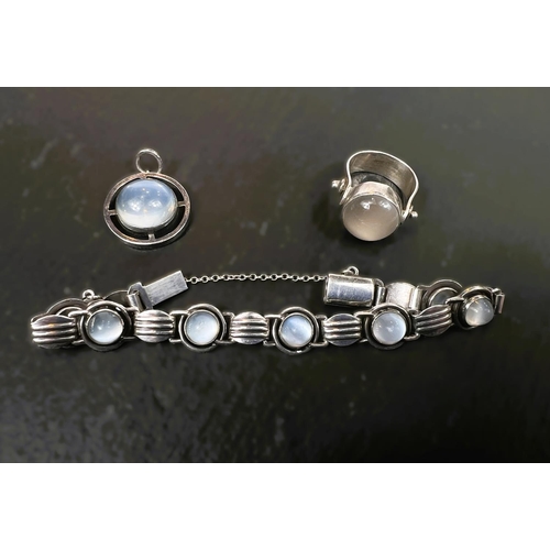 769A - A white metal and moonstone bracelet + matching circular pendant and a 3 stone ring.