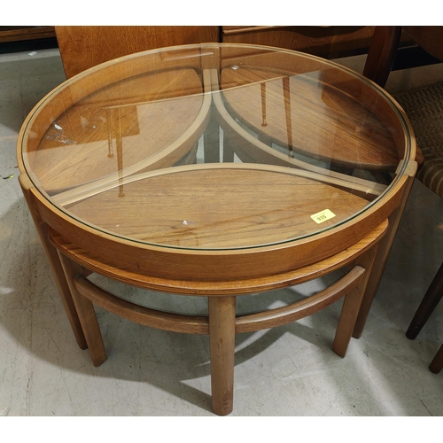 935 - A 1970's nest of 4 teak occasional tables, 1 with circular glass top, the others with oval tops