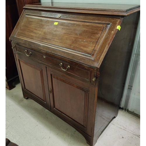 975 - A mahogany bureau with single drawers and double cupboards below, fall front interior, organised sec... 