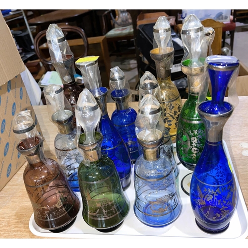 587G - 12 various coloured liqueur decanters with silvered decoration of Venice