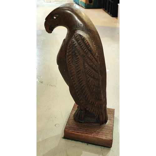 75E - A carved figure of an eagle with white eyes