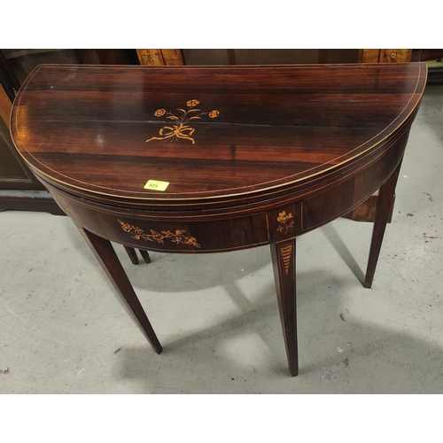 925 - A pair of Sheraton period rosewood card tables, the fold-over demilune tops with boxwood line and fl... 