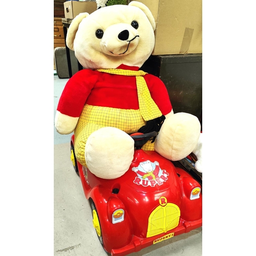 355 - A very large Rupert Bear plush teddy bear, a peddle car and a rocking Rupert