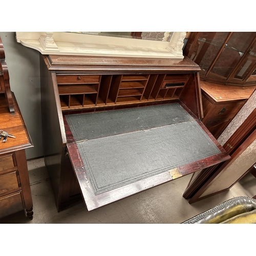 935 - A mahogany bureau with single drawers and double cupboards below, fall front interior, organised sec... 