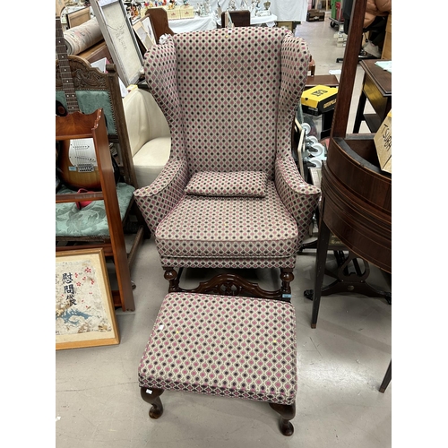 936 - A mid 20th century wing back armchair and footstool in the Georgian style, re-upholstered in pink/pu... 