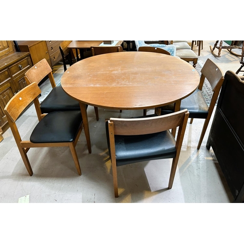 932 - A mid 20th century teak dining table, circular form with drop leaves and a set of 6 matched teak din... 