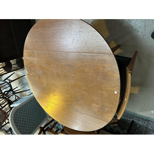 932 - A mid 20th century teak dining table, circular form with drop leaves and a set of 6 matched teak din... 