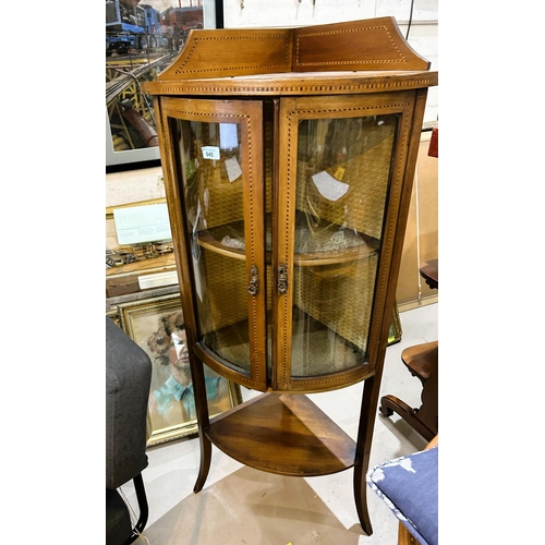 945 - A mahogany inlaid floor standing corner display unit with bow front, double doors, shelf under