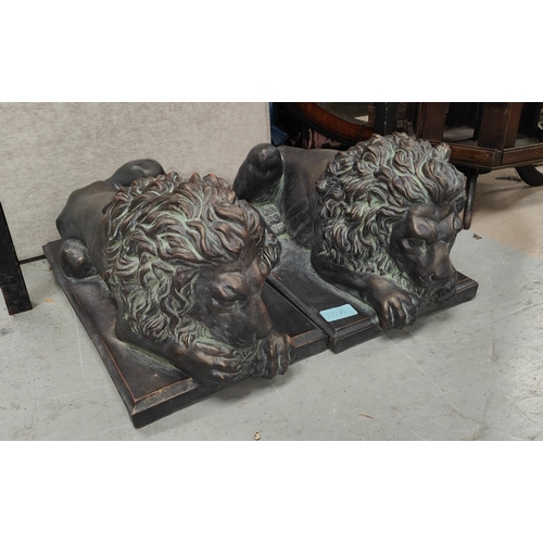 50A - A pair of good sized bronzed composition threshold lions reclining, length 45cm