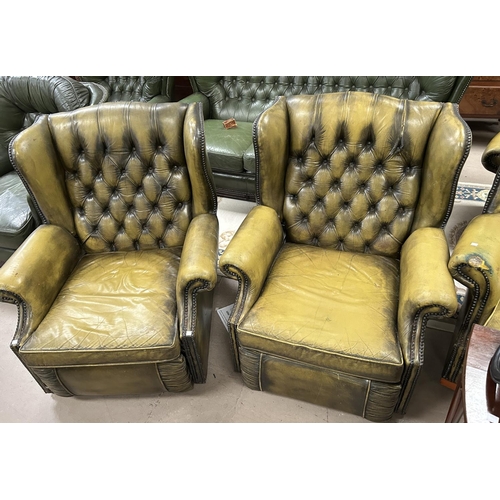 872 - A green leather effect Chesterfield style reclining armchair with deep button back with studded deco... 