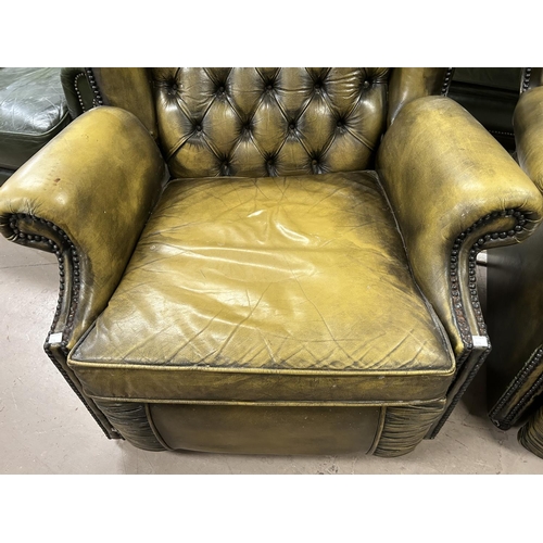 872 - A green leather effect Chesterfield style reclining armchair with deep button back with studded deco... 