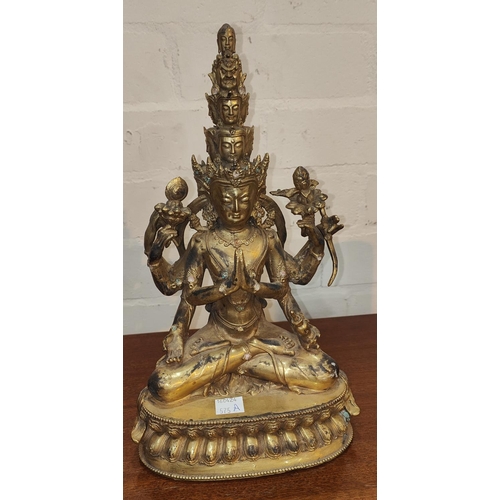 437 - A Chinese gilt bronze figure of multi face buddha seated, height 28cm.