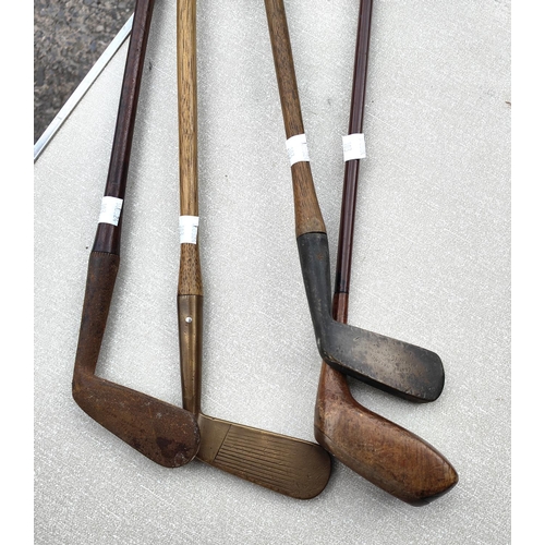 103 - An early wood and metal golf putter, three other early golf clubs with wooden shafts