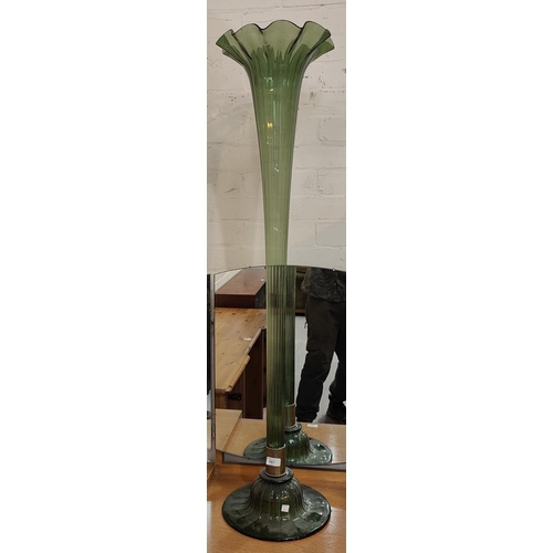 587 - A large floor standing trumpet vase in green glass, 124cm