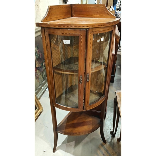 877 - A mahogany inlaid floor standing corner display unit with bow front, double doors, shelf under