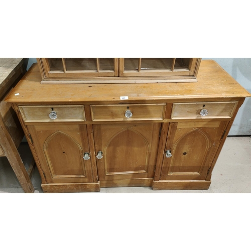 923 - A Victorian stripped pine dresser base with 3 frieze drawers and triple arched cupboard drawers