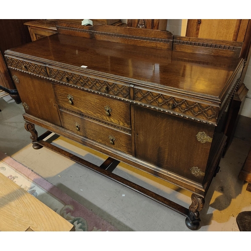 965 - A 1930's oak sideboard with 3 frieze drawers and two central drawers with 2 side cupboards