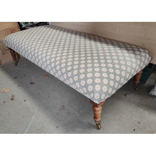 972 - A Victorian style large rectangular pouffe with turned legs and castors, upholstered in blue fabric