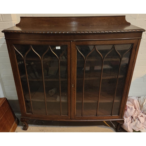 991 - A late 19th century oak display cabinet enclosed by 2 glazed doors with gadrooned rim and ball and c... 