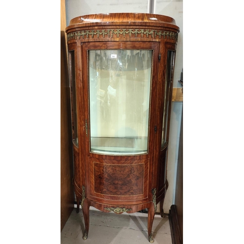 994 - A Louis XVI style bow front walnut display cabinet with ormolu mounts figured reserve panels and tap... 