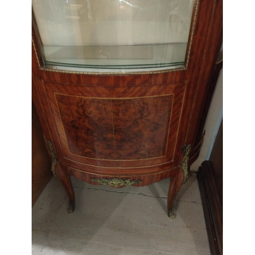 994 - A Louis XVI style bow front walnut display cabinet with ormolu mounts figured reserve panels and tap... 