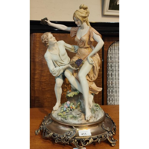 411 - A Capodimonte style group of a boy and a girl with grapes, signed 