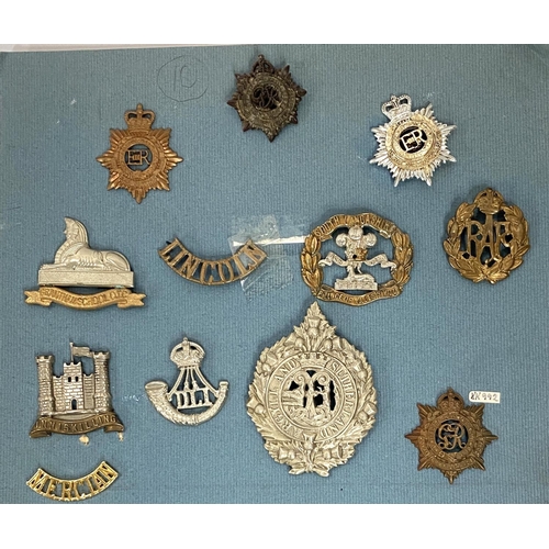 254 - A collection of Military badges on card including various  regiments