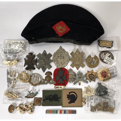 257 - A collection of military badges and buttons and a military beret