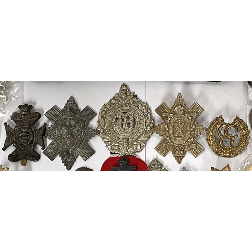 257 - A collection of military badges and buttons and a military beret