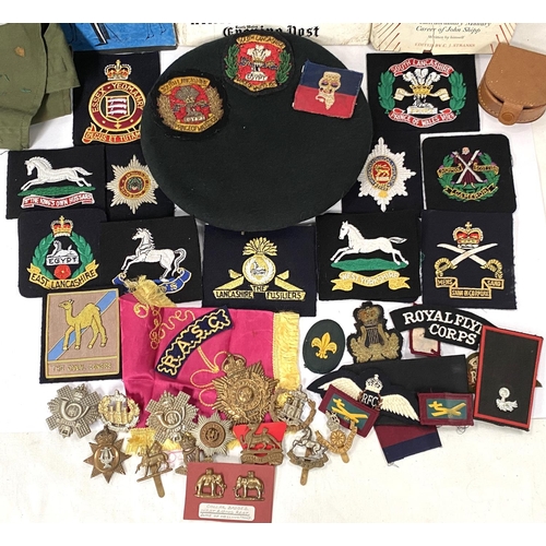 271 - A collection of interesting military cloth shoulder and other badges, metal military badges, beret e... 