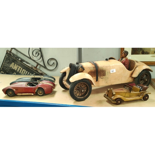 345 - A large model of a vintage open top car with driver, length 61cm; 3 small vintage car models