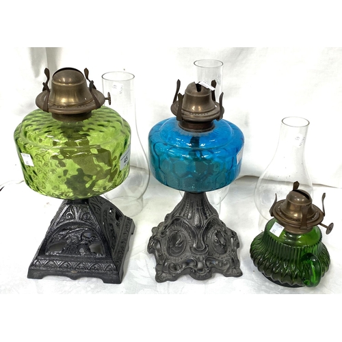 45 - Two Victorian cast iron and coloured glass oil lamps and a smaller lamp